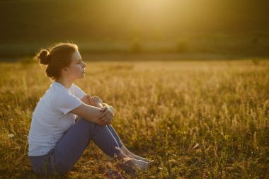 kadın yoga uygulamaları ve lotus pozisyonu üzerinde derin derin düşünür 