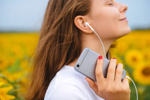 young beautiful girl  listen the music in your smartphone, outdo