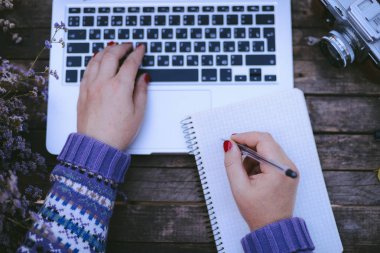 Ev işlerinde çalışan bir kadın klavyede çalışıyor. Yakın plan.