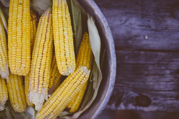 Kırsal ahşap masadaki koçanlarda taze mısır, yakın plan.
