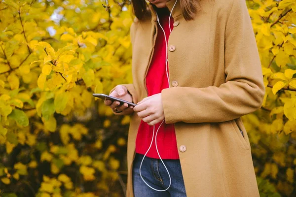 Девушка-хипстер отправляла смс на смартфон осенью — стоковое фото