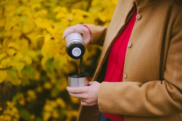 Viajero chica vertiendo té de la taza de termo, al aire libre. Mujeres jóvenes — Foto de Stock