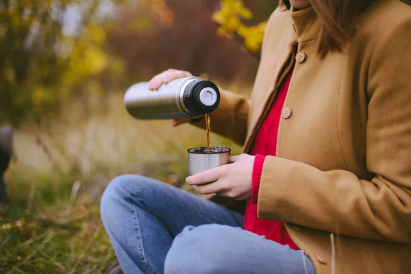 Viajero chica vertiendo té de la taza de termo, al aire libre. Mujeres jóvenes — Foto de Stock