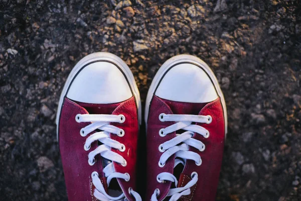 Sneakers op de weg. weg. rode sneakers op asfalt, bovenaanzicht. — Stockfoto