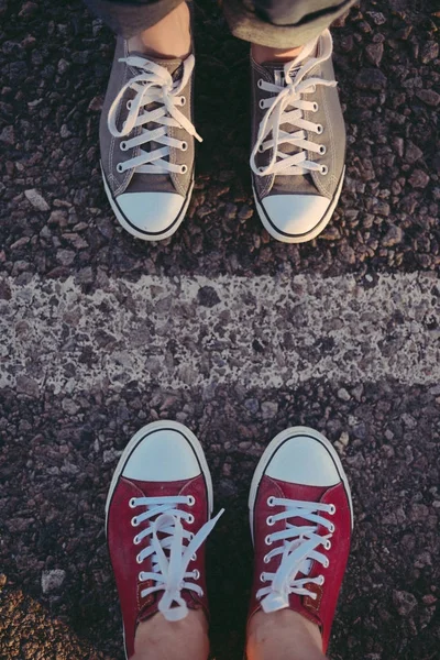 Sneakers op de weg. weg. rode sneakers op asfalt, bovenaanzicht. — Stockfoto