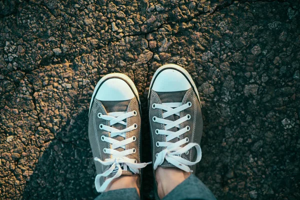 Sneakers op de weg. weg. rode sneakers op asfalt, bovenaanzicht. — Stockfoto