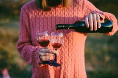 kırmızı şarap bardağa dökülüyor.