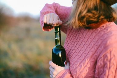 kırmızı şarap bardağa dökülüyor.