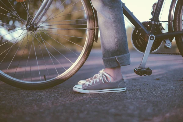 Beautiful young woman riding pink bicycle in green park. Legs of — Stock Photo, Image