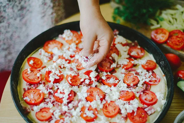 Raw pizza dough with sauce and ingredients on wooden table. Fres