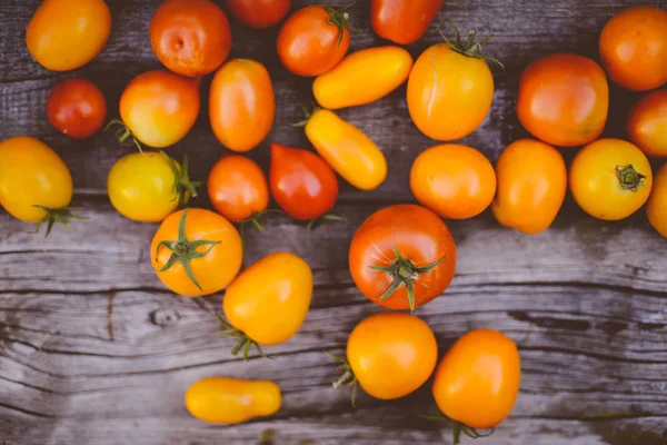 Close-up de tomates frescos e maduros sobre fundo de madeira — Fotografia de Stock