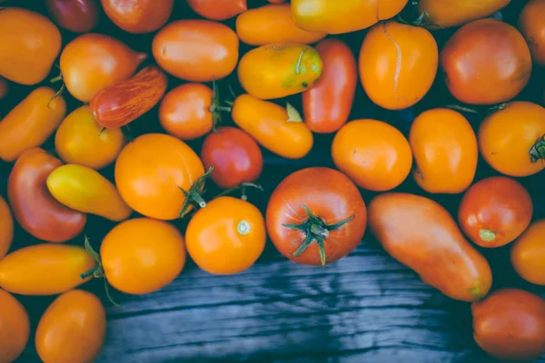 Close-up de tomates frescos e maduros sobre fundo de madeira — Fotografia de Stock