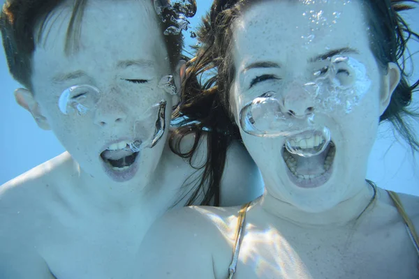 Chico y chica gritando bajo el agua — Foto de Stock