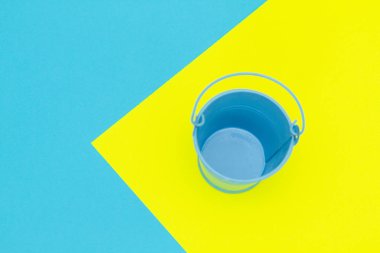 Renkli kağıtların üzerindeki mavi boş metal kova.. 