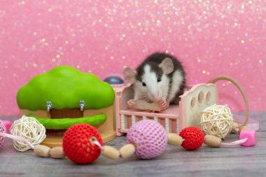 Küçük gri bir fare oyuncak bir yatakta oturuyor.. 