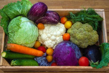 Taze sebzeler - lahana, havuç, kabak, patlıcan ve domatesler marketteki tahta kutuda.