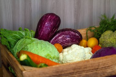 Taze sebzeler - lahana, havuç, kabak, patlıcan ve domatesler marketteki tahta kutuda.