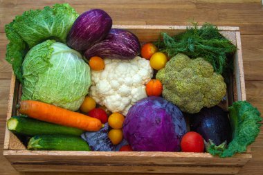 Taze sebzeler - lahana, havuç, kabak, patlıcan ve domatesler marketteki tahta kutuda.