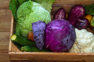 Taze sebzeler - lahana, havuç, kabak, patlıcan ve domatesler marketteki tahta kutuda.