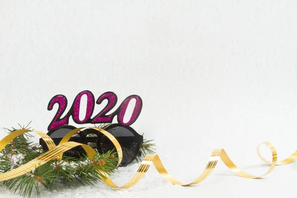Noel kompozisyonu. Üzerinde 2020 yazan güneş gözlüğü. Arka planda firavun dalı ve flama şeridi var. Noel, kış, yeni yıl konsepti