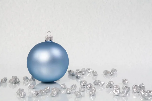 明るい背景に青いクリスマスボールと光沢のある輝く小石 伝統的な冬の装飾 — ストック写真