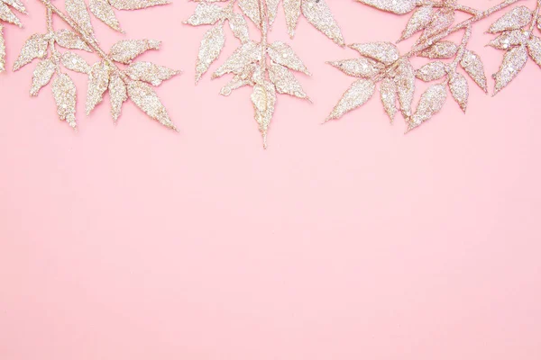 Yeni yıl, kış tatili konsepti. Düz konum, üst görünüm, kopyalama alanı. Parlak Noel dekorasyonu. Pembe arka planda yaprakları olan bir dal..