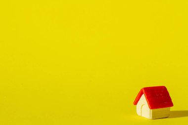 Little toy house on a yellow background. clipart