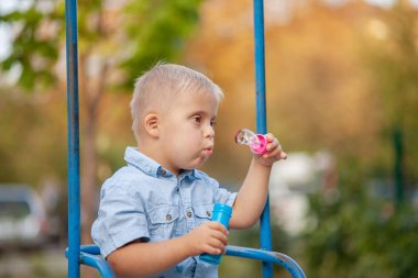 Engelli bir çocuğun günlük hayatı. Down Sendromlu bir çocuk oyun alanında oynuyor. Kromozom ve genetik bozukluk..