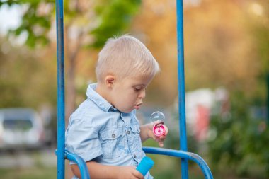 Engelli bir çocuğun günlük hayatı. Down Sendromlu bir çocuk oyun alanında oynuyor. Kromozom ve genetik bozukluk..