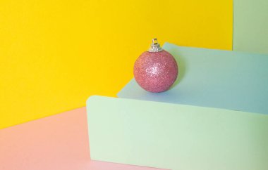 Renkli bir arka planda pembe buzlu top. 3D Noel kompozisyonu. Mutlu yıllar ve mutlu Noeller.!