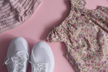 Tatile çıkıyoruz. Düz yatıyordu - elbise, spor ayakkabılar ve pembe arka planda panama.