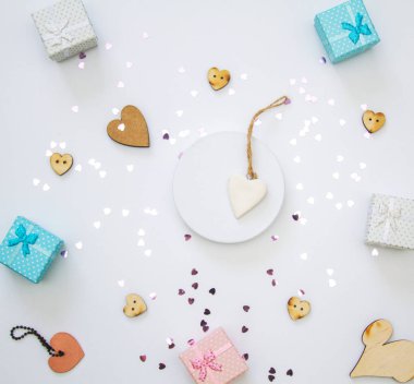 Hafif arka planda küçük hediye kutuları ve kalpler. Pastel renkte şenlikli bir kompozisyon. Sevgililer Günü için kavram.