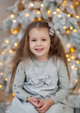 Parlak Noel ışıkları içindeki küçük tatlı kız, yeni yıl 2021 ve Noel, süslemeli yeni yıl ağacı.