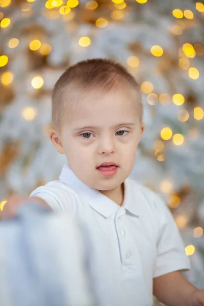 Portrait of a boy with Down Syndrome. Genetic and mental illness in a disabled child.