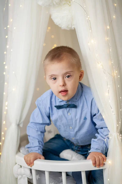 Portrait of a boy with Down Syndrome. Genetic and mental illness in a disabled child.
