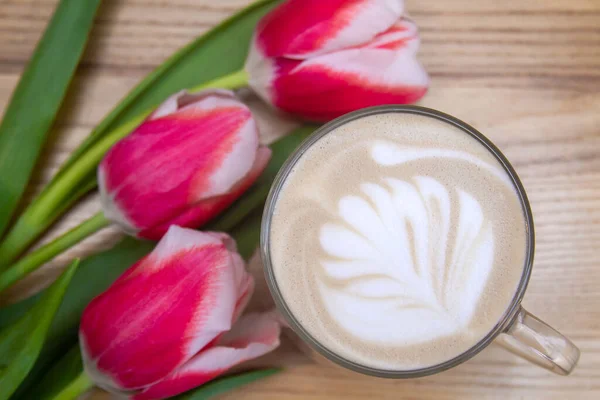 Latte Drewnianym Stole Blisko Trzy Czerwone Tulipany — Zdjęcie stockowe