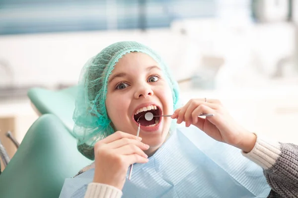 Girl at the dentist\'s appointment. Inspection of the oral cavity and teeth in a child.