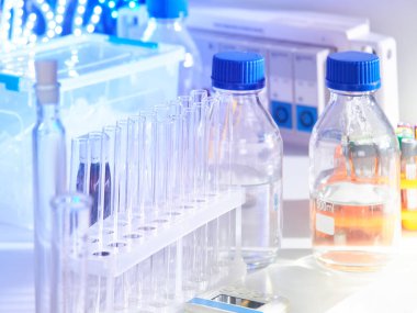 Cam şişelerde tampon çözümler, çeşitli cam ve plastik tüplerde sıvı bilimsel veya tıbbi örnekler içeren bilimsel bir altyapı. Sığ Dow, tonlu resim.