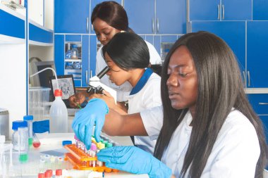COVID-19 pcr nükleik asit taraması devam ediyor. Genç Afrikalı kadın bilim adamları test laboratuarında tıbbi teknisyenler çalışıyor. Kan ve ağız örnekleri. Yeni Coronavirus 'taki nükleik asit analizi.