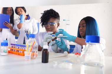 Hastane test laboratuvarı. Genç Afrikalı bilim adamları, tıbbi teknisyenler veya tıp öğrencileri birlikte çalışarak zatürree hastalarına teşhis koymak için kan, nükleik asit ve diğer tıbbi testler yapıyorlar..