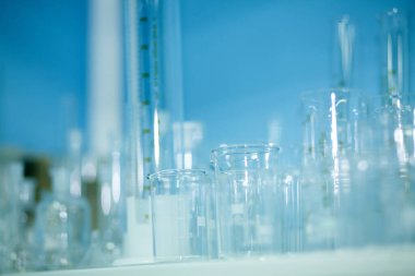 Tıbbi test laboratuvarı, hastane araştırma laboratuarı test tesisi. Çeşitli deneyler ya da klinik testler için raflarda çeşitli laboratuvar vitrinleri var. Şişeler, cam tüpler, şişeler ve mavi huniler.