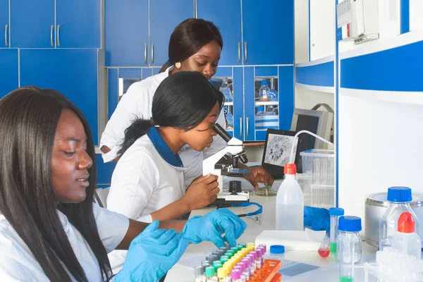 PCR analysis for nucleic acid from novel coronavirus. COVID-19 pcr nucleic acid screening in progress. Young African women scientists professionals work in test lab. Blood, mouth swab samples