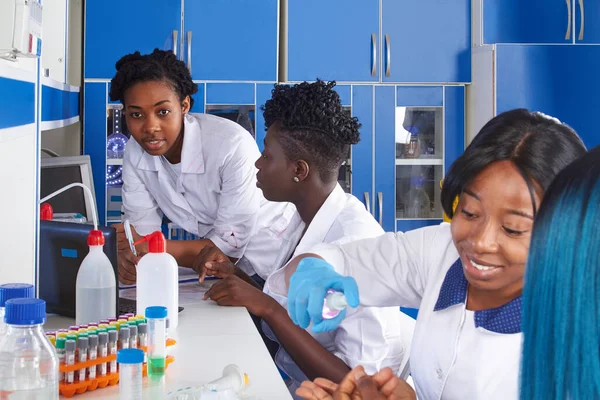 Genç Afrikalı kadın bilim adamları, tıp teknolojisi, tıp veya lisansüstü öğrencileri, pozitif enerjik kadınlar birlikte çalışarak kan testi, nükleik asit, Covid-19 ve diğer tıbbi testleri yerel hastaneler için yaparlar.