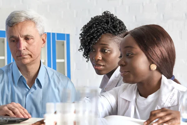 Ledare För Vita Team Och Afrikanska Läkarstudenter Som Arbetar Testlaboratorium — Stockfoto