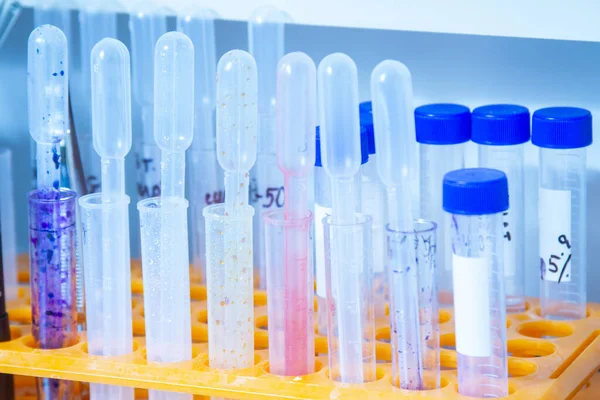 Cam şişelerde tampon çözümler, çeşitli cam ve plastik tüplerde sıvı bilimsel veya tıbbi örnekler içeren bilimsel bir altyapı. Sığ Dow, tonlu resim.