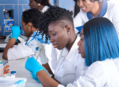 Afrikalı kadın teknisyenler test laboratuarındaki hasta örnekleri üzerinde PCR testleri yapıyorlar. Kadın uzmanlar, yeni koronavirüs SARS-CoV-2 için rna tanımlamak için nükleik asit testi yapıyorlar. Enerjik ekip çalışması.