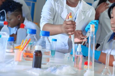 Test tesisi. Genç Afrikalı bilim adamları, tıbbi teknisyenler veya tıp öğrencileri birlikte çalışarak zatürree hastalarına teşhis koymak için kan, nükleik asit ve diğer tıbbi testler yapıyorlar..