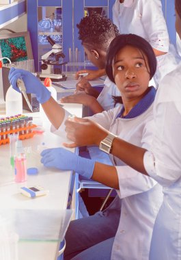 İnsanları koronavirüsten koruyan aşının geliştirilmesi dünya çapında covid-19 virüsü salgınına neden oldu. Laboratuvarda çalışan enerjik Afrikalı kadın bilim adamları veya öğrenciler