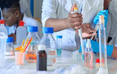 Test tesisi. Genç Afrikalı bilim adamları, tıbbi teknisyenler veya tıp öğrencileri birlikte çalışarak zatürree hastalarına teşhis koymak için kan, nükleik asit ve diğer tıbbi testler yapıyorlar..