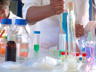 Test tesisi. Genç Afrikalı bilim adamları veya tıp öğrencileri, pozitif enerjik kadınlar, kan, nükleik asit ve Covid-19 hastalarından alınan örnekler üzerinde birlikte çalışırlar..